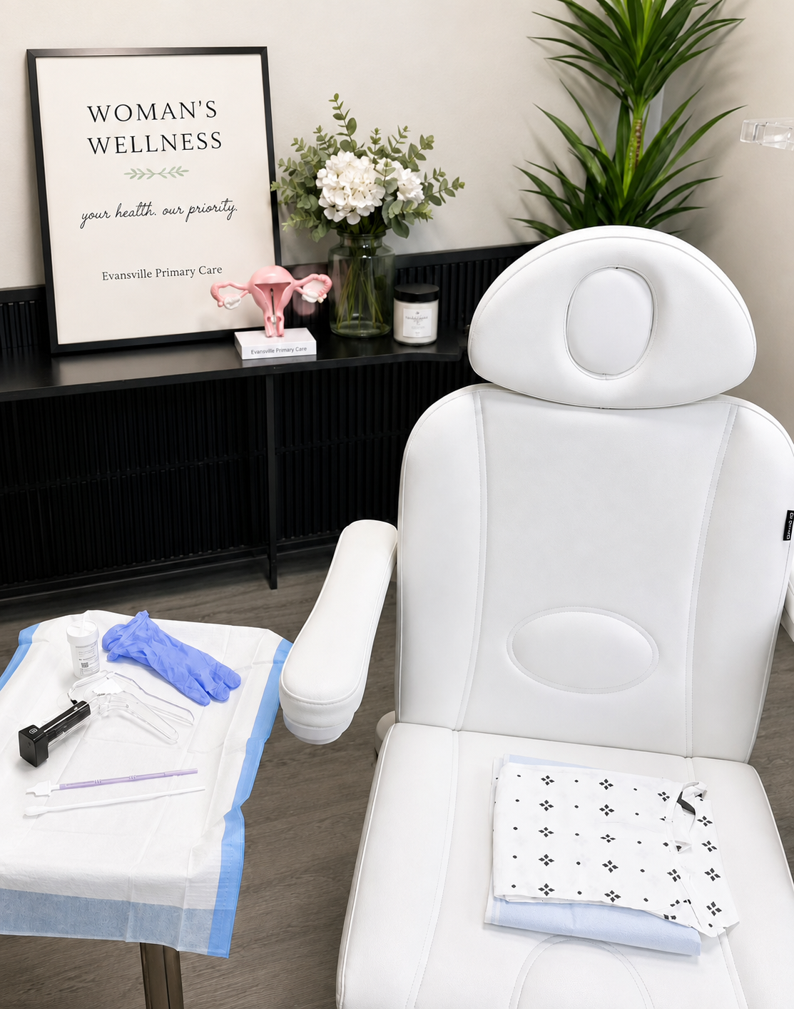 Women's wellness exam room at Evansville Primary Care with a prepared instrument tray and exam chair.