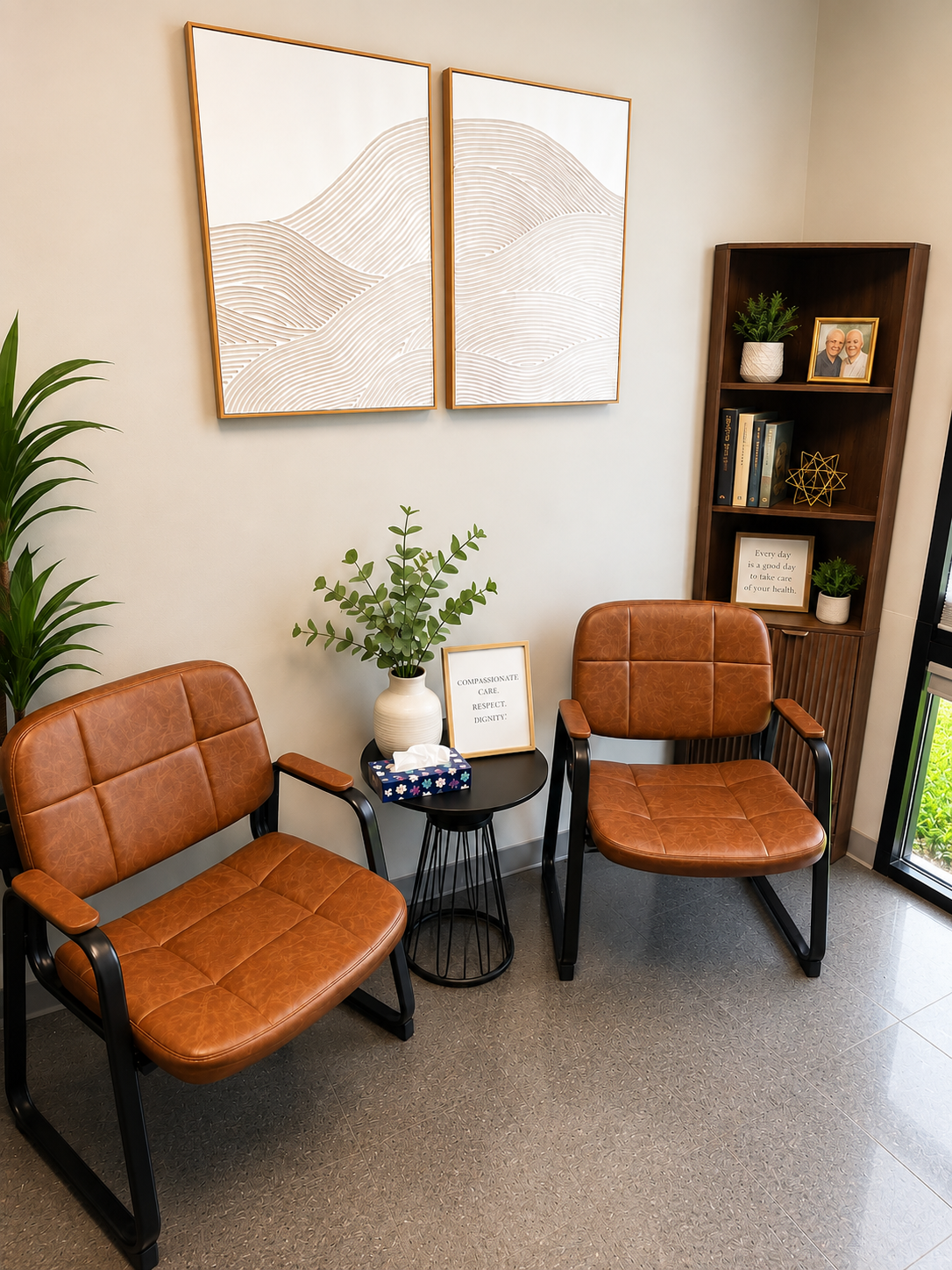 Quiet seating area at Evansville Primary Care with two leather chairs, plants and a framed reminder to take care of your health.